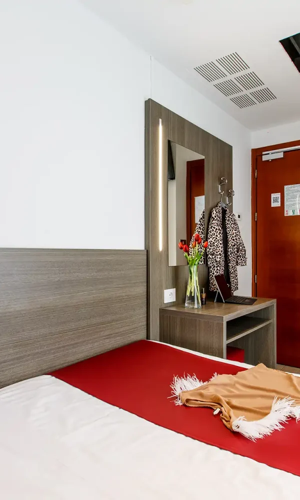 Camera d'albergo moderna con letto matrimoniale e arredamento minimalista.