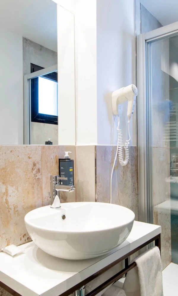 Modernes Badezimmer mit Waschbecken, Spiegel und Dusche mit blauen Fliesen.