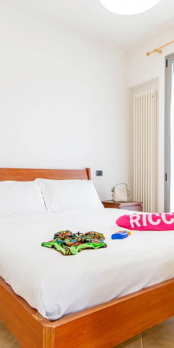 Modernes Schlafzimmer mit Holz-Doppelbett, dekoriert mit Blumen und einem Handtuch auf dem Bett.