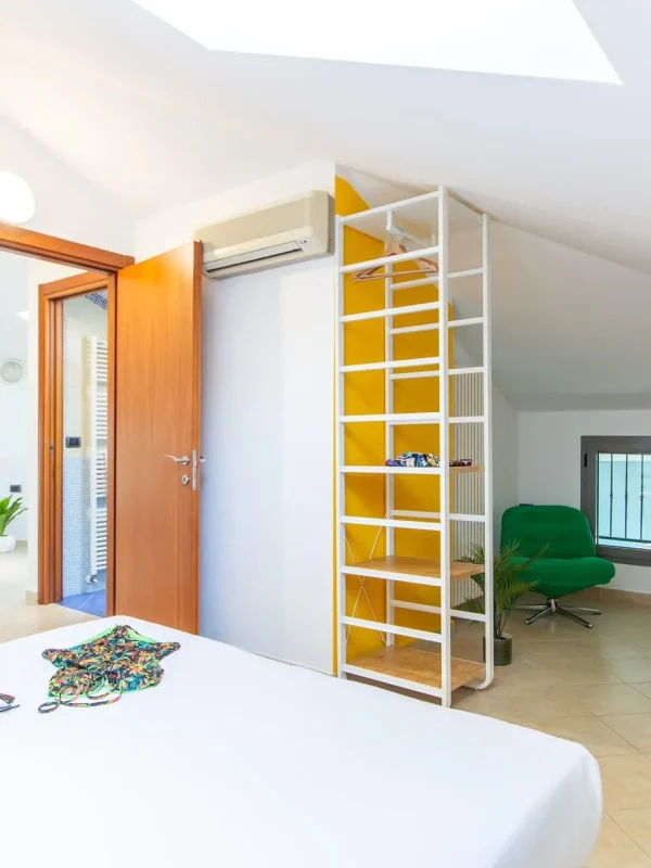 Camera da letto luminosa e moderna con dettagli colorati e arredi minimalisti.