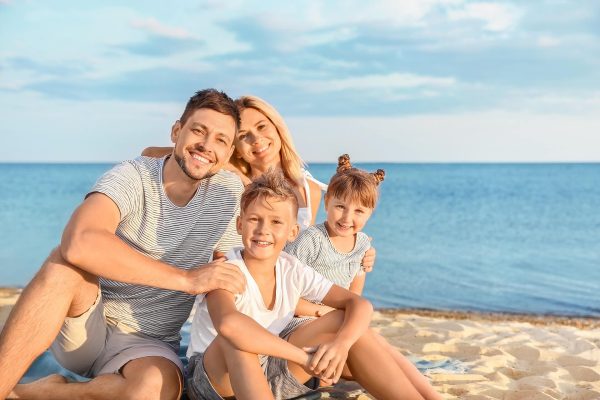 Famiglia sorridente in vacanza sulla spiaggia.