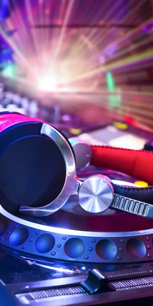 Cuffie da DJ su una console con luci colorate.