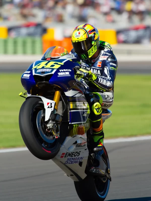 Pilota di MotoGP in impennata su una Yamaha durante una gara.