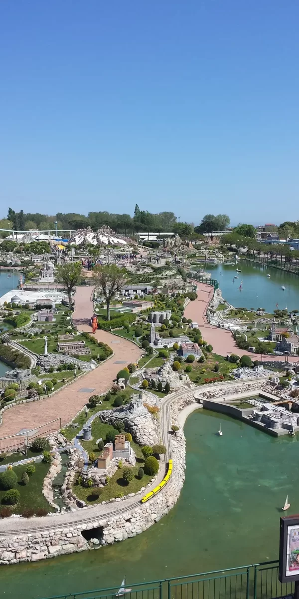 Vista panoramica su un parco di miniature con percorsi pedonali e modellini di monumenti storici circondati da acqua.